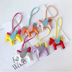 Six charms cheval ailé colorés posés sur des magazines