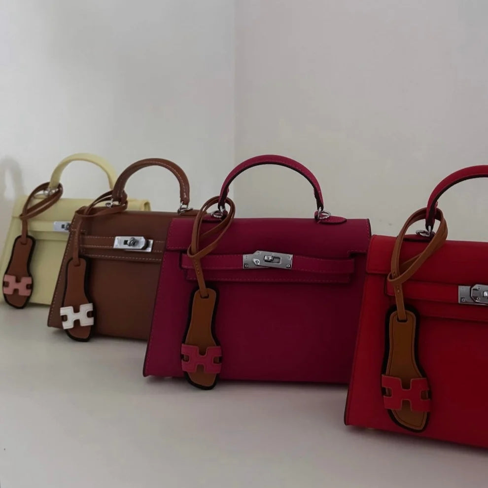 Quatre sacs colorés avec un charm sandale miniature accroché à chacun
