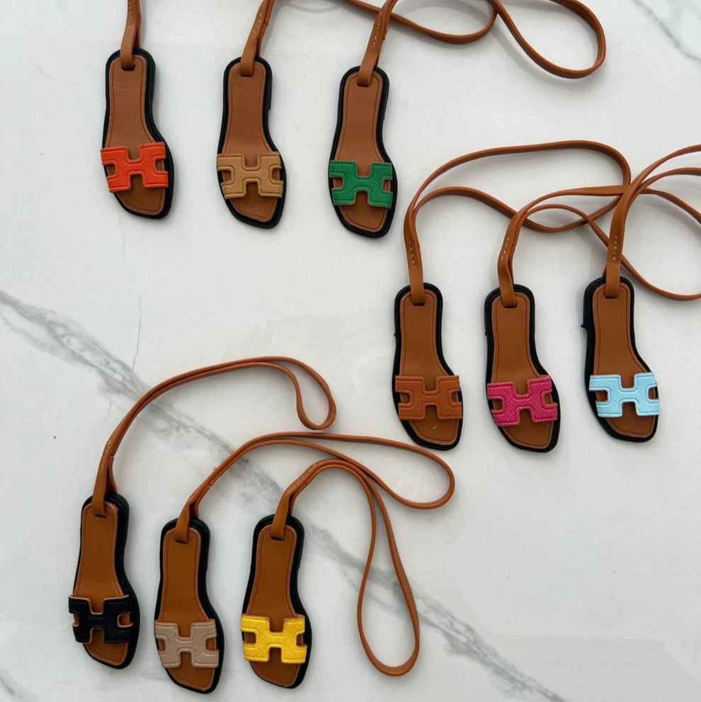 Neuf charms sandale miniature de couleurs différentes sur un marbre blanc