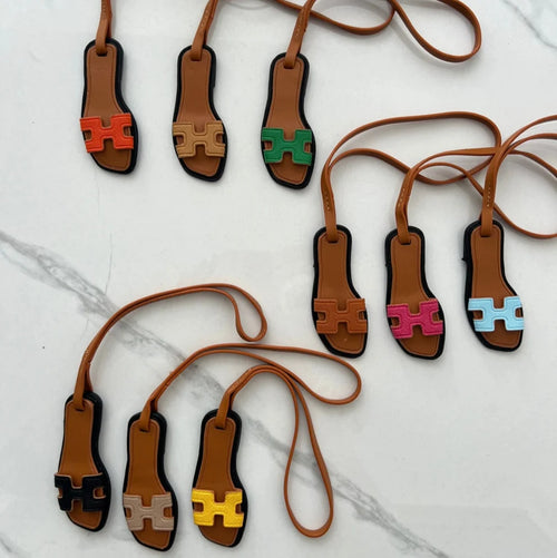 Neuf charms sandale miniature de couleurs différentes sur un marbre blanc