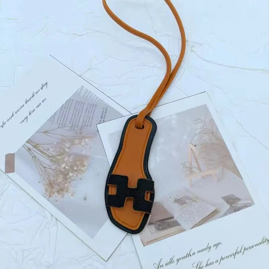 Charm sandale miniature noir avec lanière cognac
